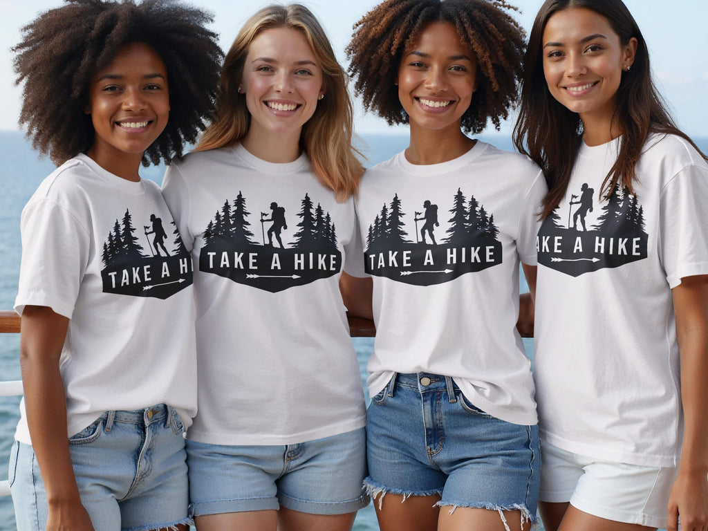 Four smiling women wear white t-shirts with black "Take a Hike" graphic on them.