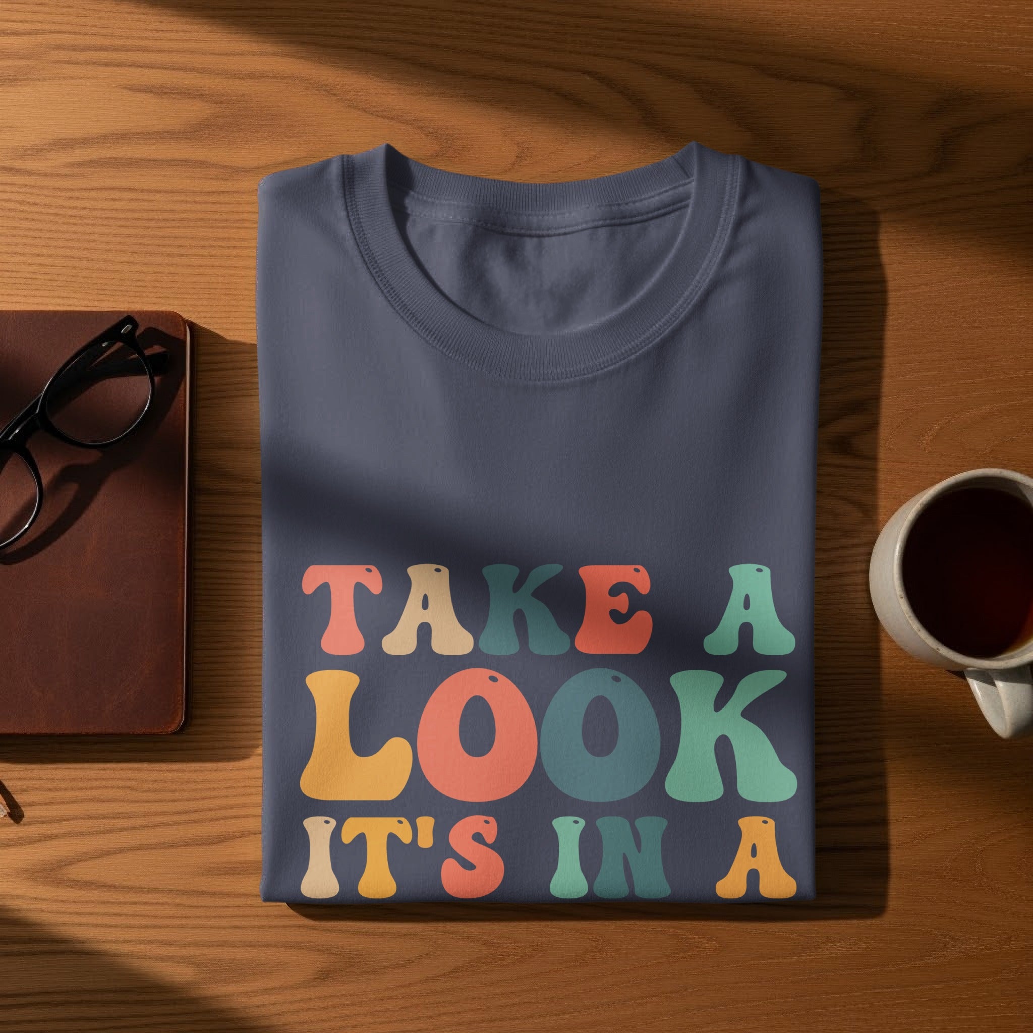 Navy t-shirt with colorful text that reads "TAKE A LOOK IT'S IN A"