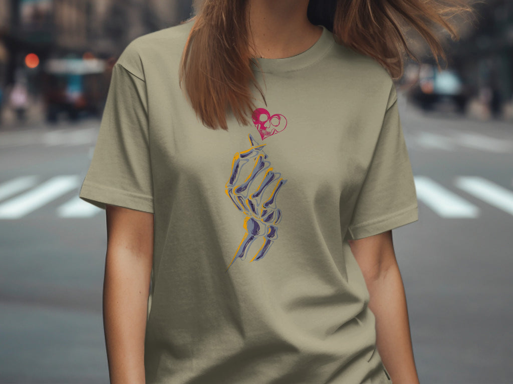 Olive t-shirt with a skeleton hand holding a pink skull heart graphic.