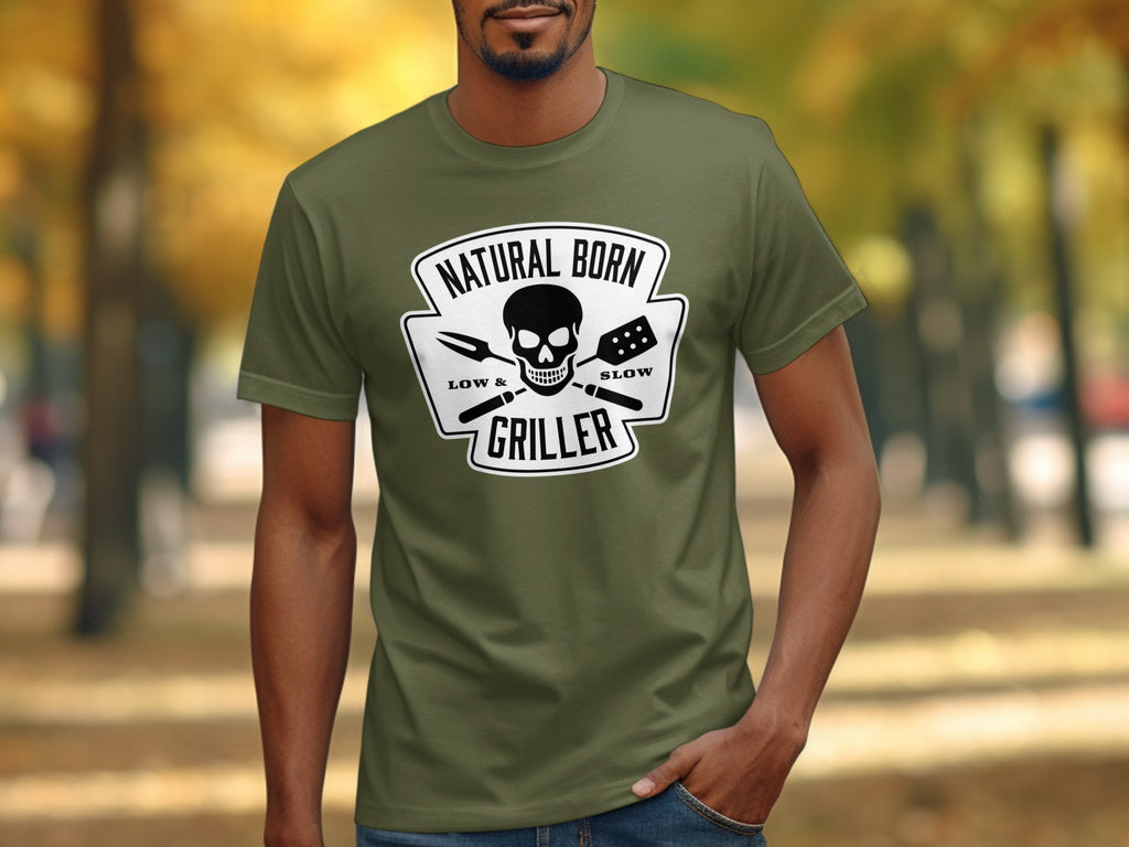 Olive green t-shirt with "Natural Born Griller" skull logo and grilling tools.