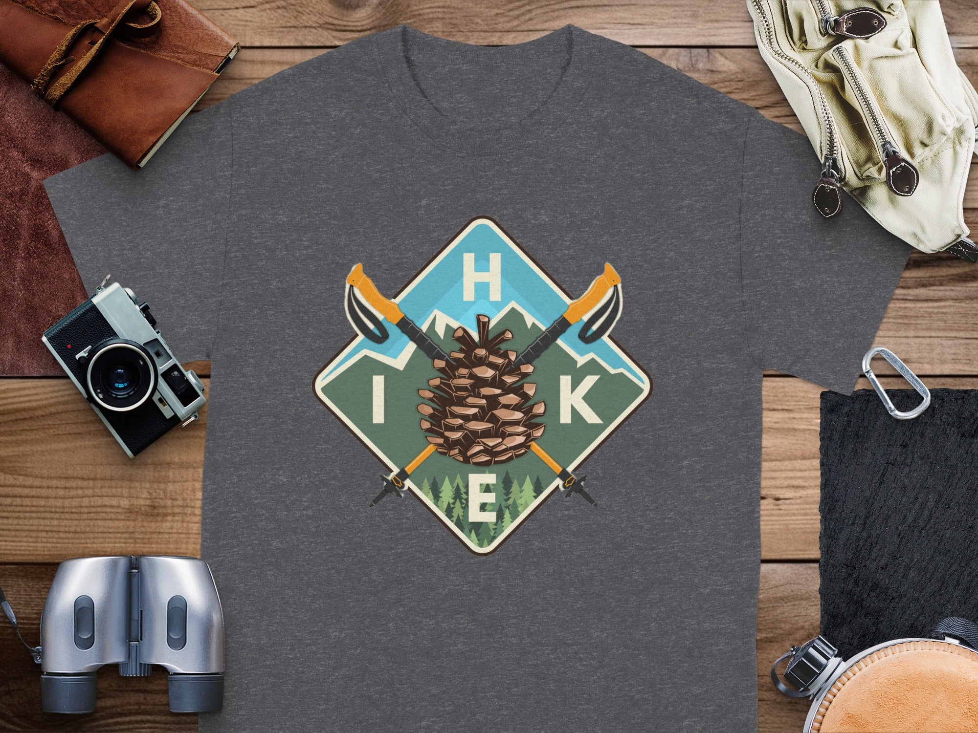 Dark grey t-shirt with a diamond graphic featuring a pinecone, mountains, and the word "HIKE".