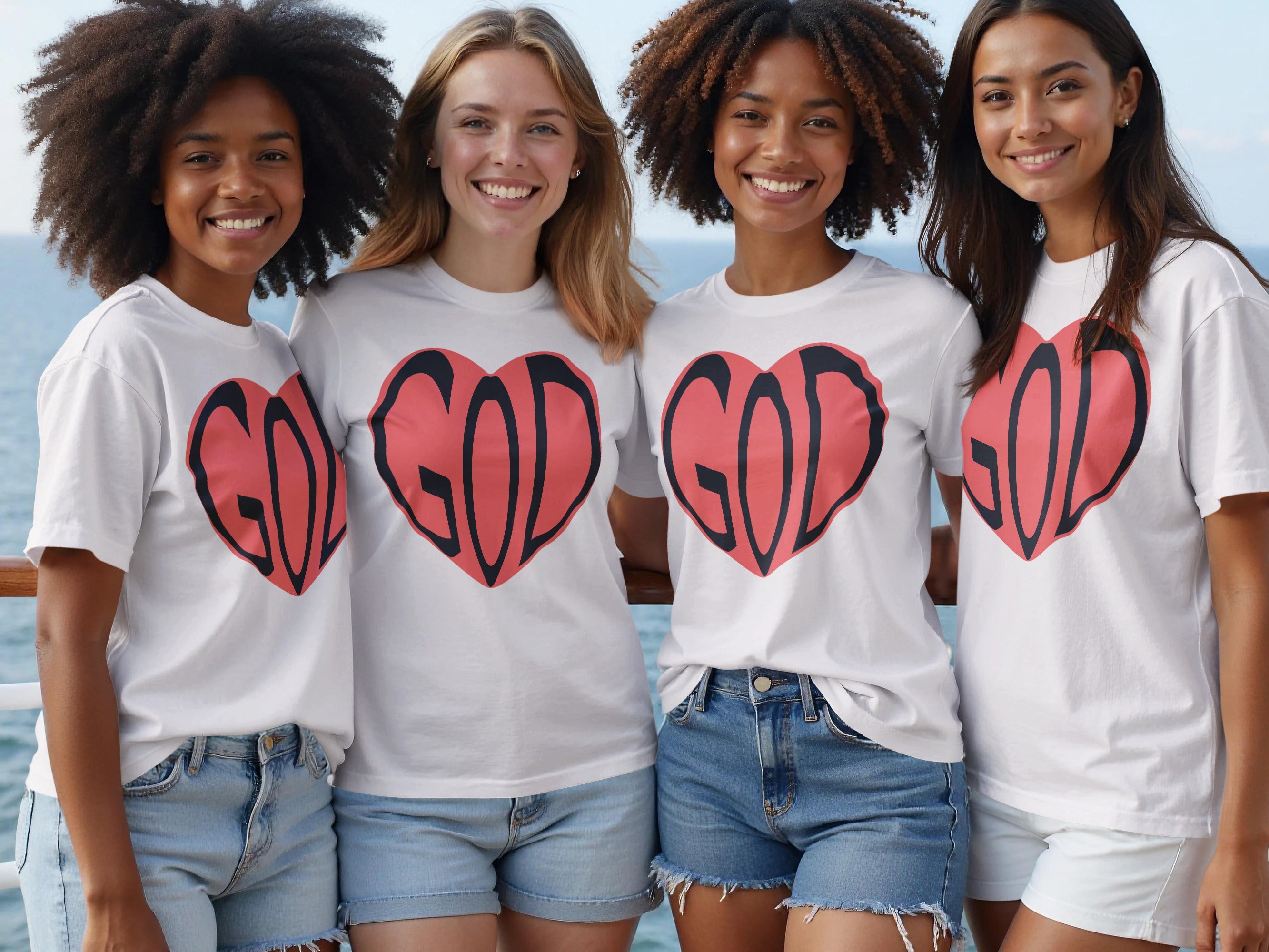 Four women wear white t-shirts with a red heart graphic containing the word "GOD".