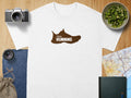 White t-shirt with brown trail running shoe graphic and text.