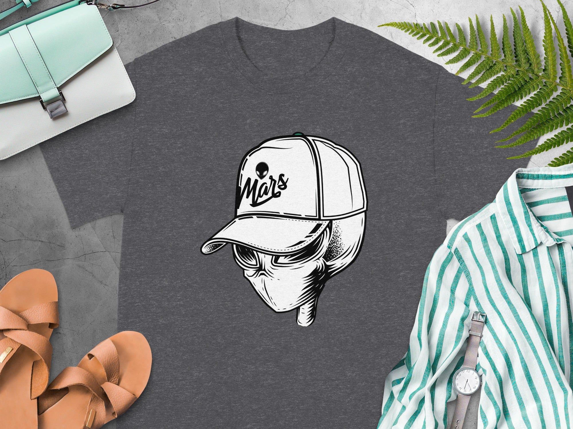Graphic alien head wearing a baseball cap with "Mars" text on a dark grey t-shirt.