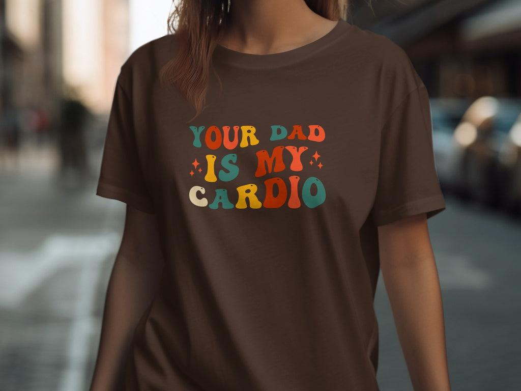 Brown t-shirt with "YOUR DAD IS MY CARDIO" in retro colorful letters.