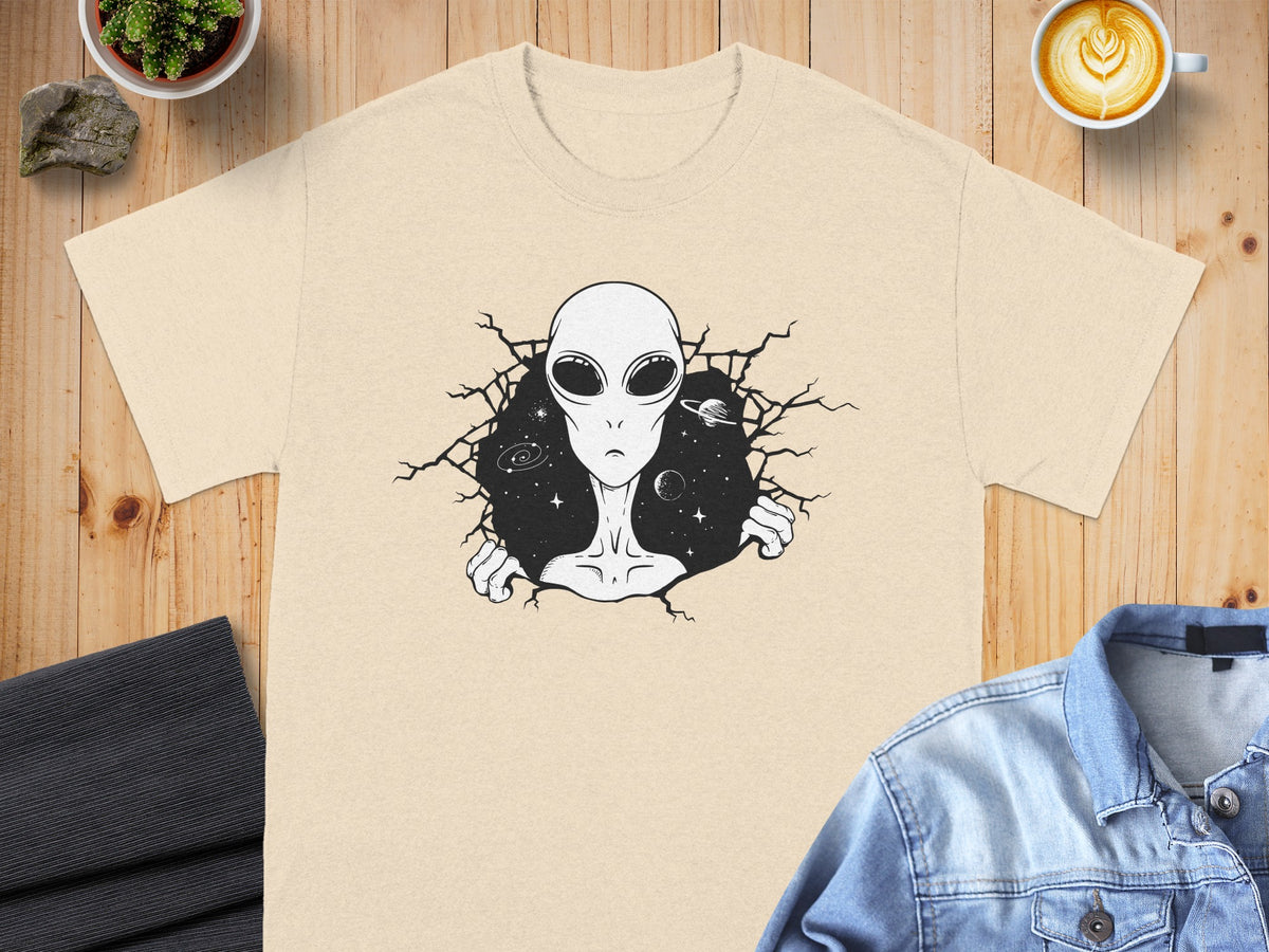 Cream t-shirt with black alien bursting through cracked space background.