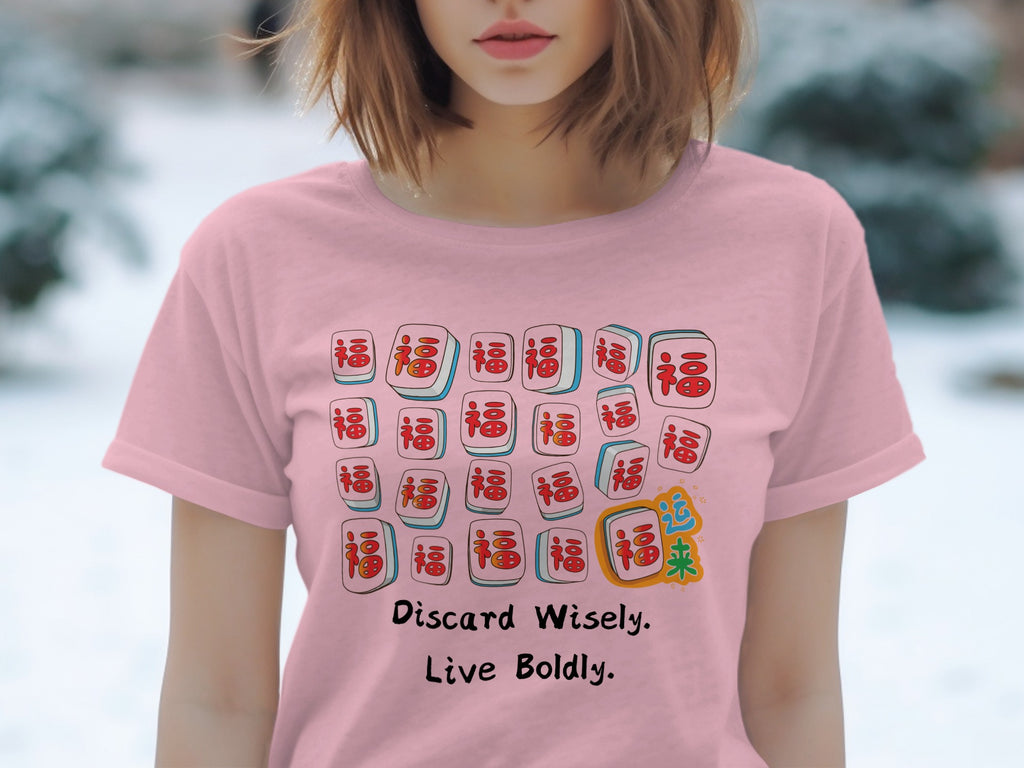 Pink t-shirt with mahjong tiles, text "Discard Wisely. Live Boldly."