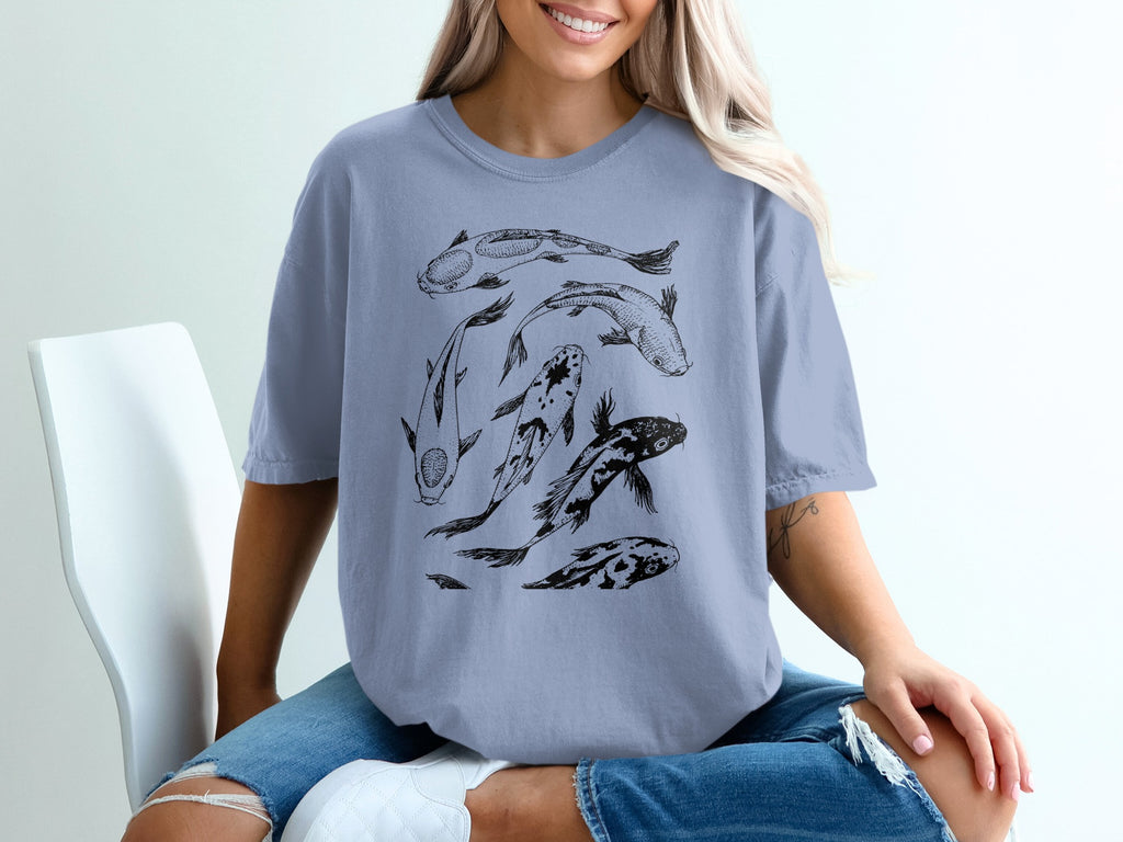 T-shirt with black line drawing of five koi fish on a light blue shirt.