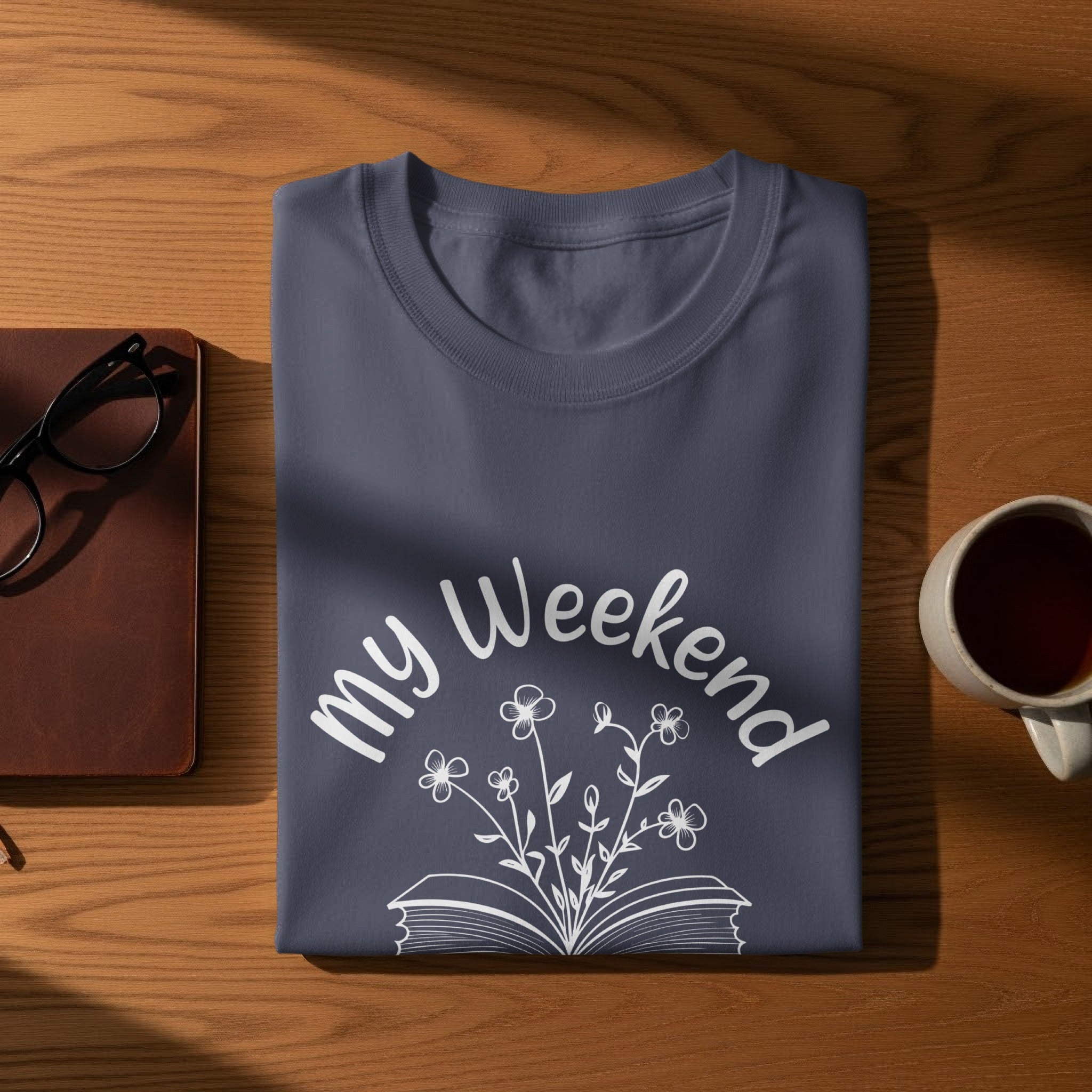 Dark blue t-shirt with illustration of an open book and flowers, text "my Weekend"