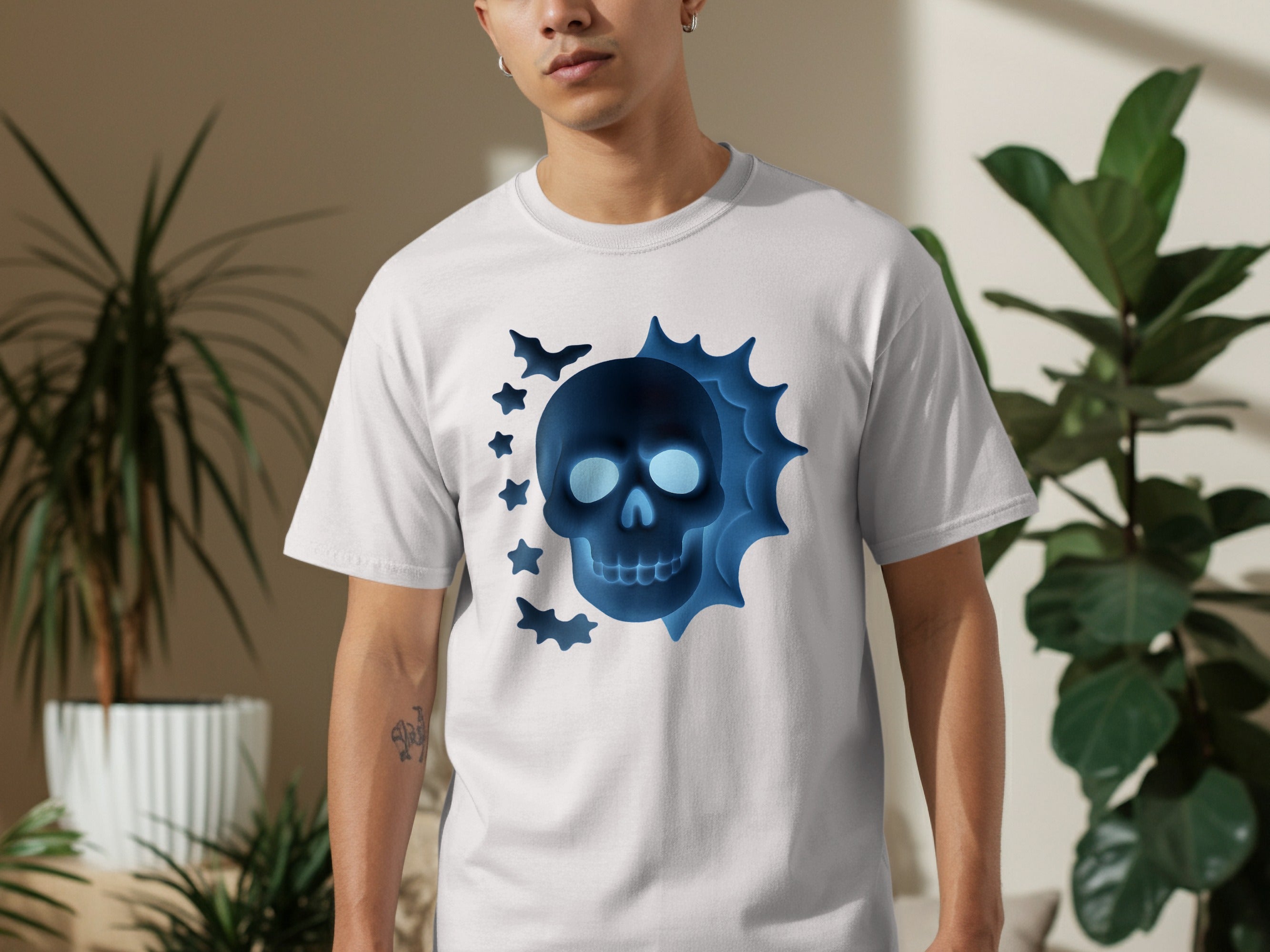 White t-shirt with a glowing blue skull and bats Halloween design.