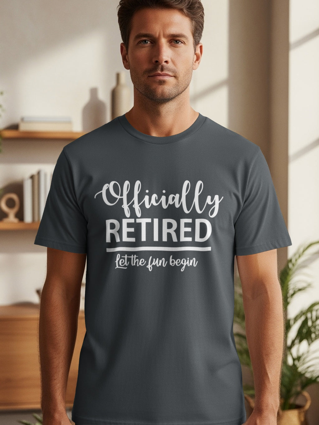 Man wearing a dark grey t-shirt with "Officially RETIRED let the fun begin" in white lettering.
