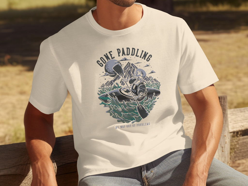 T-shirt with graphic: skeleton kayaking, "Gone Paddling" title, "My Way Out of Problems" text.