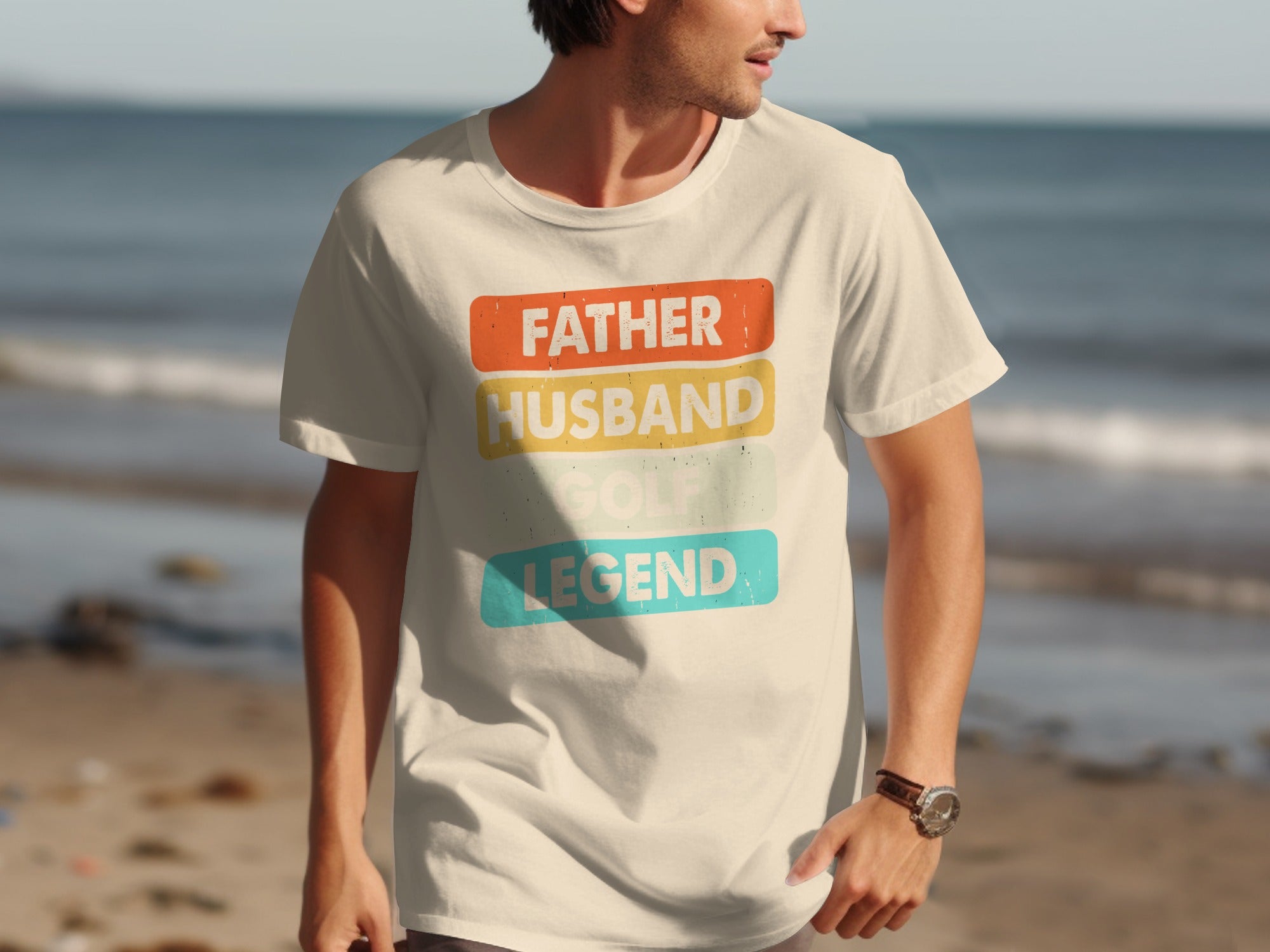 Cream t-shirt with text "FATHER HUSBAND GOLF LEGEND" on a beach.