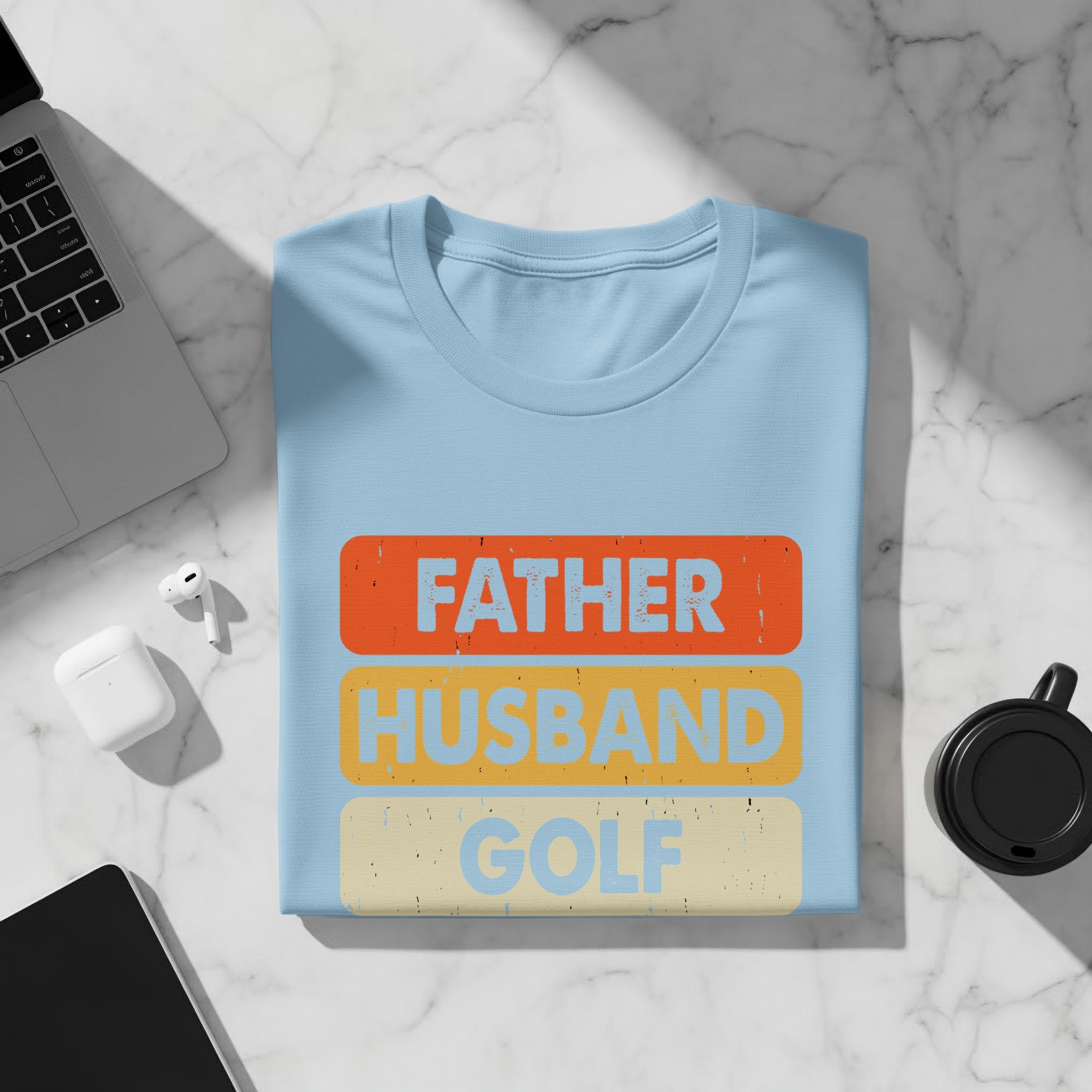 Light blue t-shirt with distressed text "FATHER HUSBAND GOLF" layered on colored blocks.