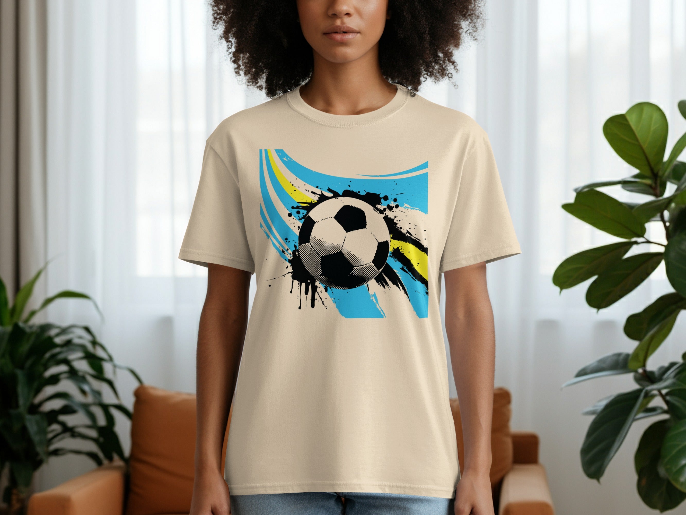T-shirt with a black and white soccer ball graphic on a blue and yellow abstract background.