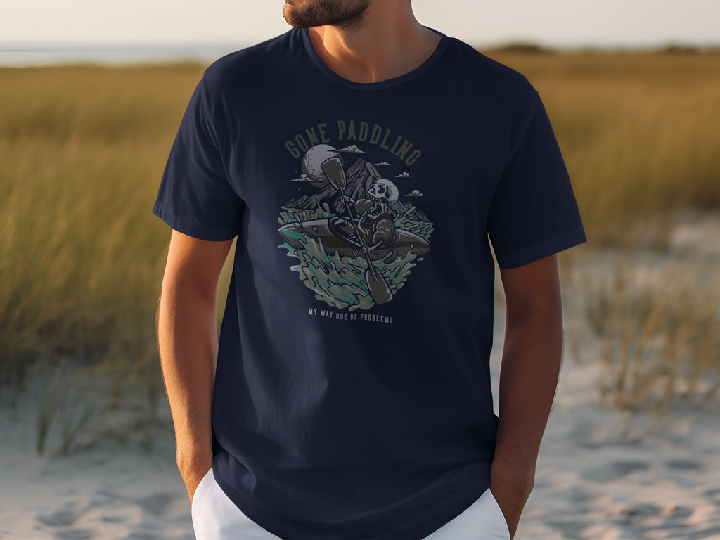 Navy t-shirt with skeleton kayaking graphic and text "GONE PADDLING MY WAY OUT OF PROBLEMS."