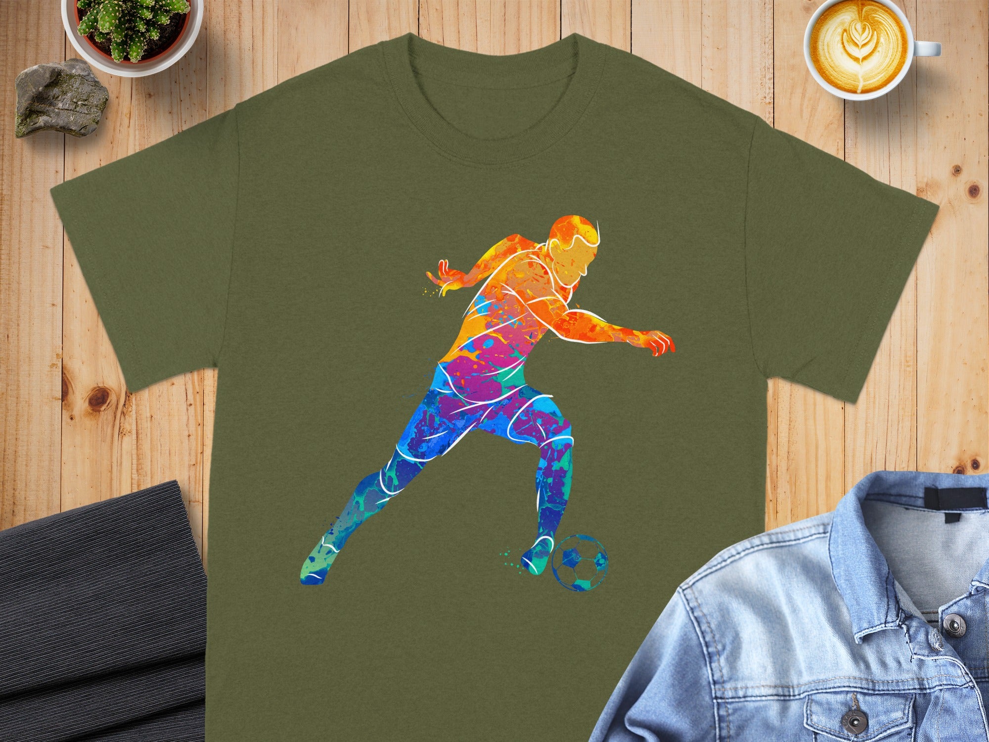 Green t-shirt with colorful watercolor soccer player silhouette graphic.