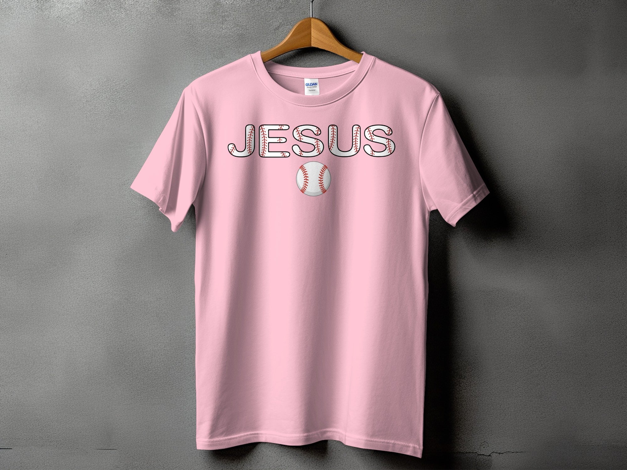 Pink t-shirt with "JESUS" text designed with baseball stitching and a baseball.