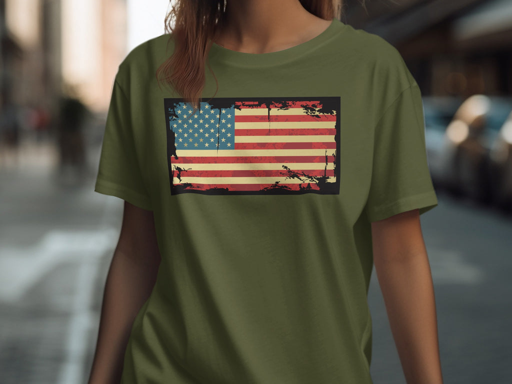 Distressed American flag graphic on a green t-shirt worn by a person.