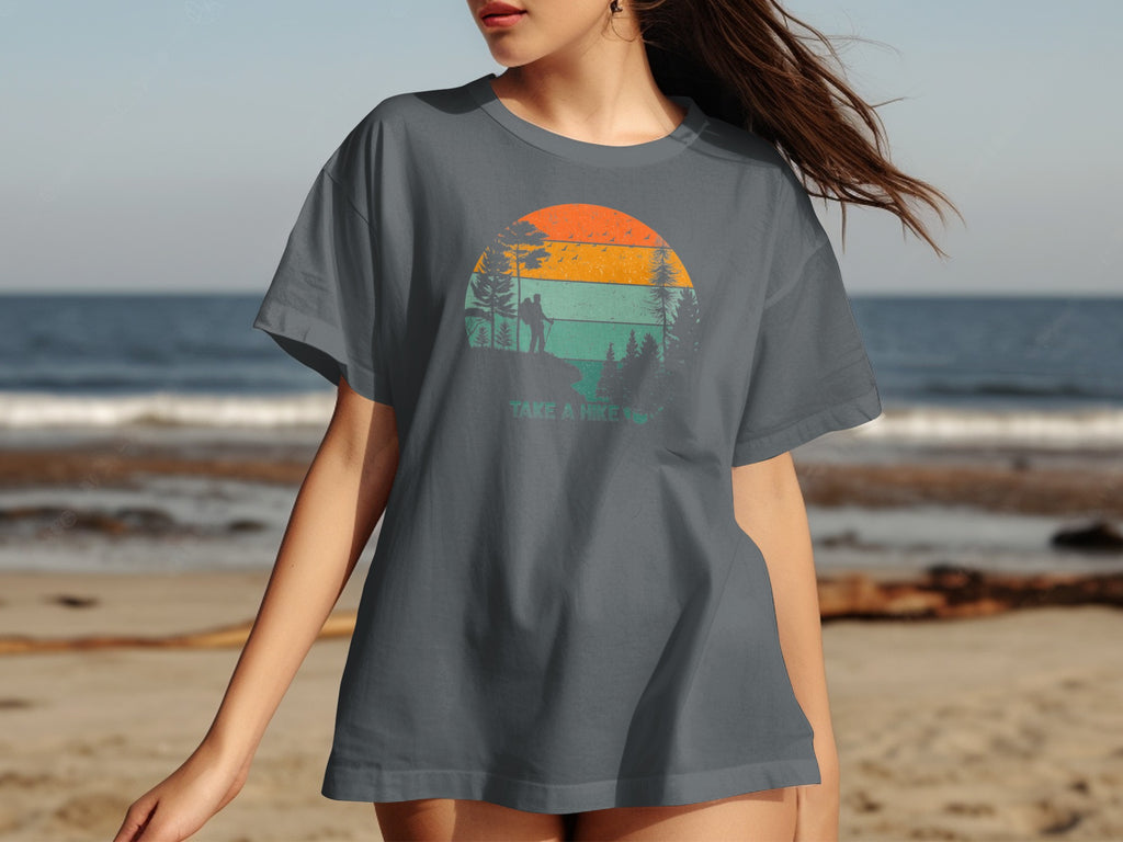 Gray t-shirt with sunset graphic featuring hiker, trees, and text "TAKE A HIKE".