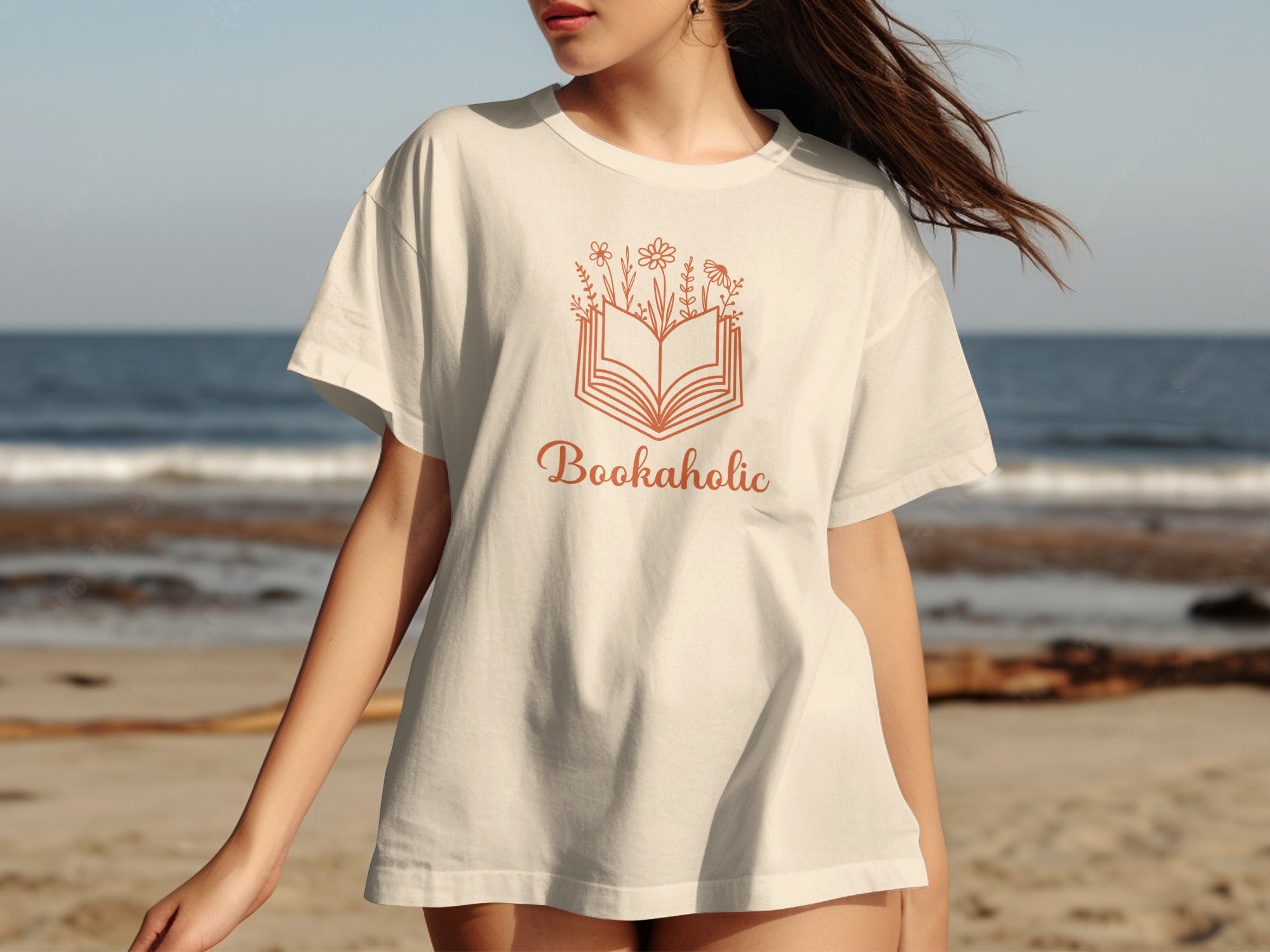Cream t-shirt with an open book and flowers graphic and "Bookaholic" text.