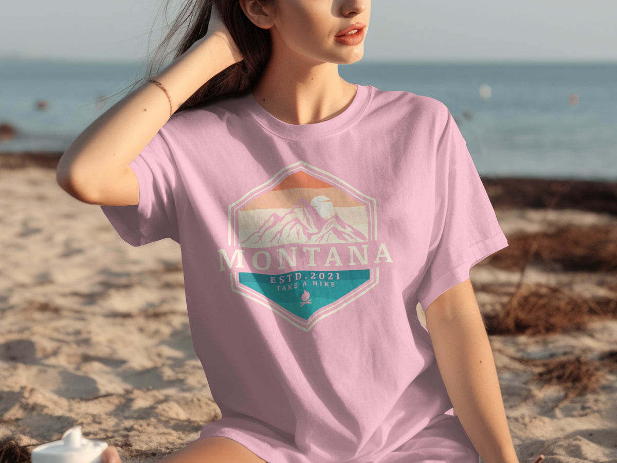 Pink t-shirt with "Montana Estd. 2021 Take a Hike" mountain logo.