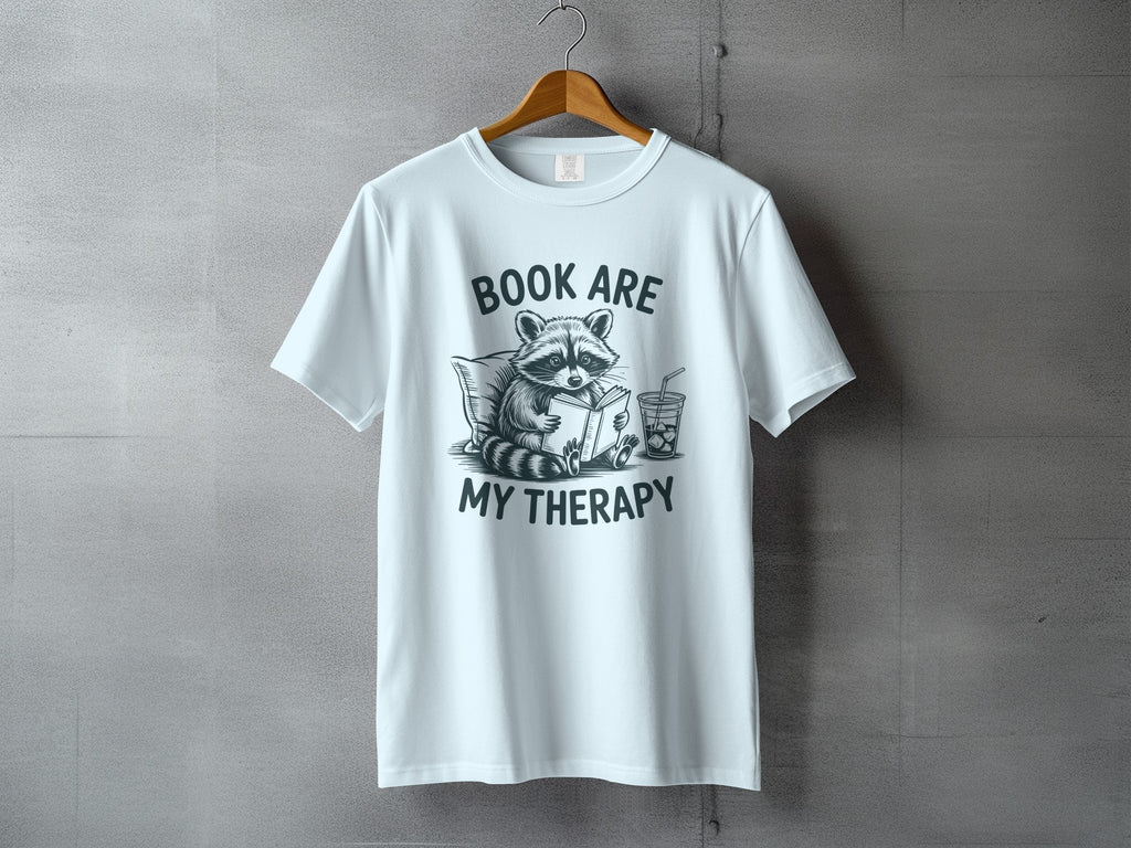 White t-shirt with raccoon reading, "BOOK ARE MY THERAPY" text.