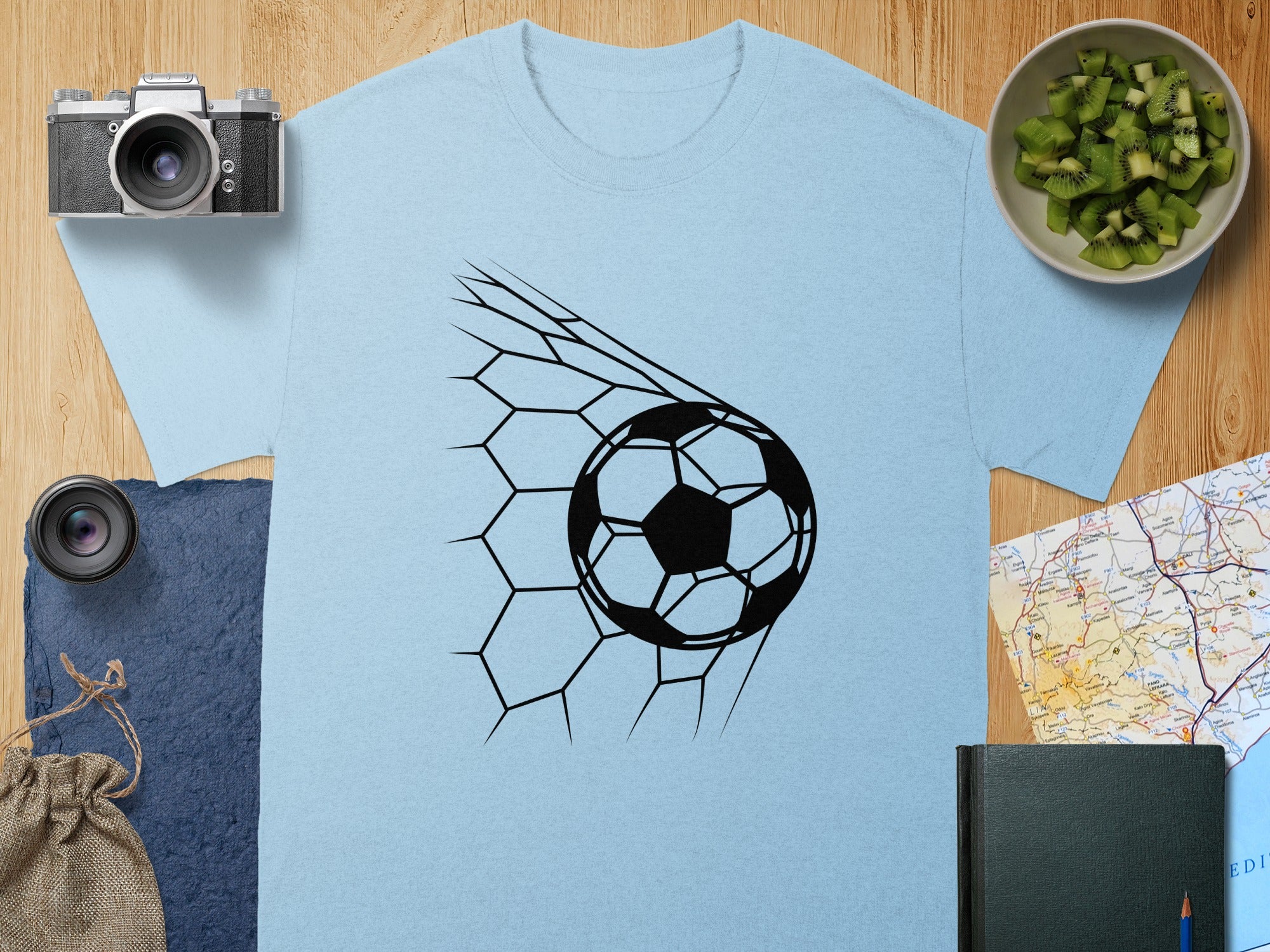 Light blue t-shirt with black soccer ball in net graphic.