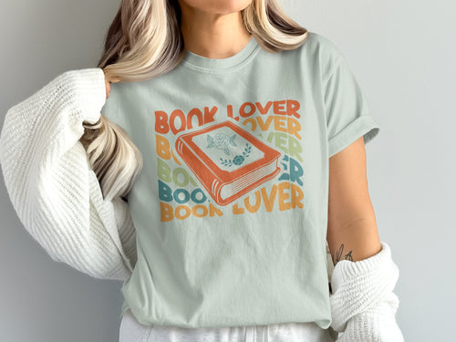 Light blue t-shirt with stacked "BOOK LOVER" text and an orange book graphic.