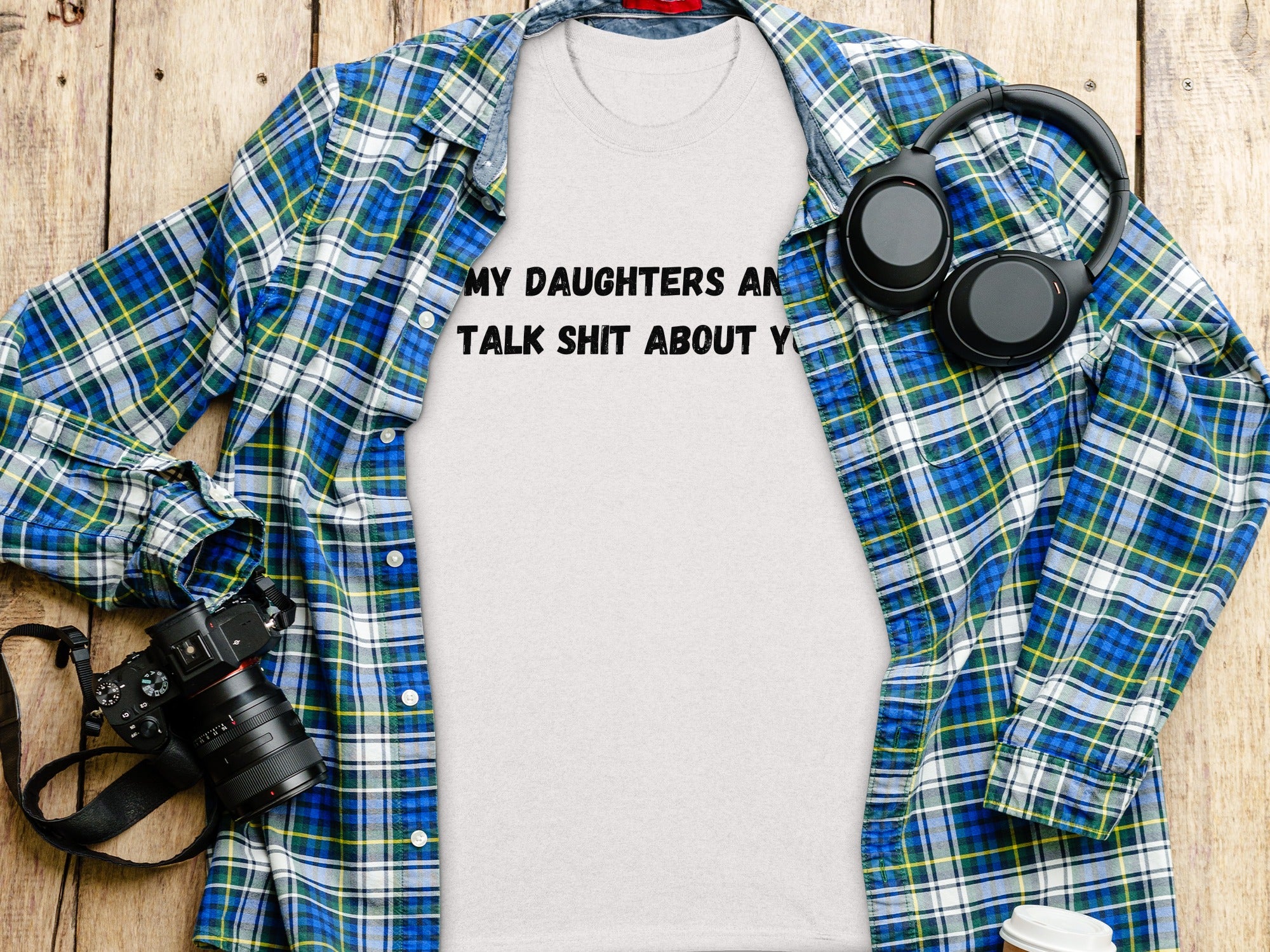 White t-shirt with black text: "MY DAUGHTERS AN TALK SHIT ABOUT Y", layered with plaid shirt.
