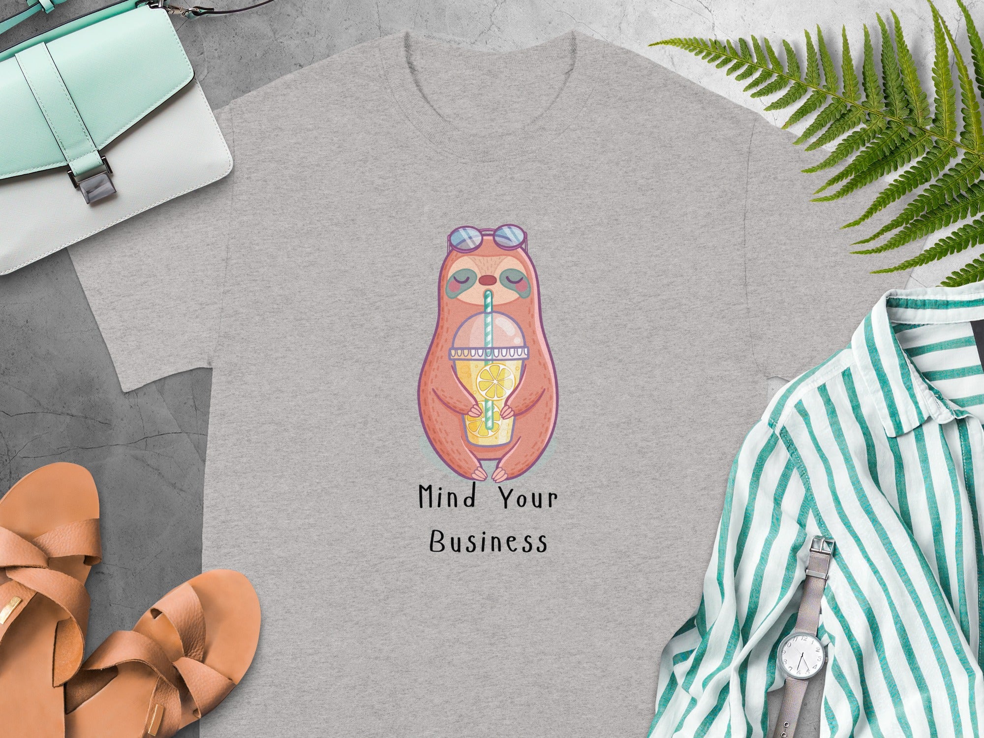 Grey t-shirt with cartoon sloth illustration and text "Mind Your Business".