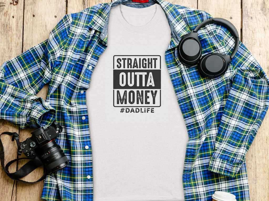 T-shirt with "STRAIGHT OUTTA MONEY #DADLIFE" text, open plaid shirt, headphones, camera.