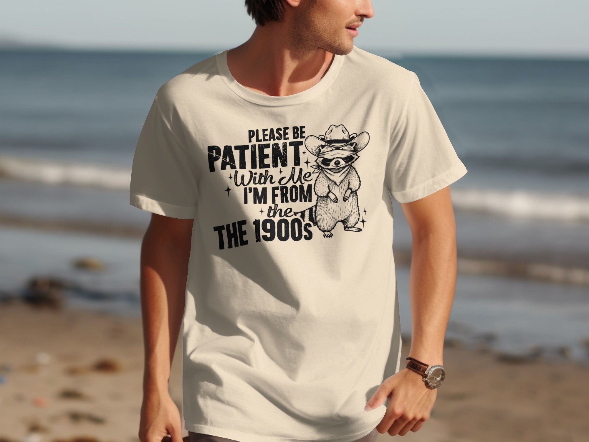 T-shirt with a raccoon wearing a cowboy hat and sunglasses, text says "Please be patient with me, I'm from the 1900s".