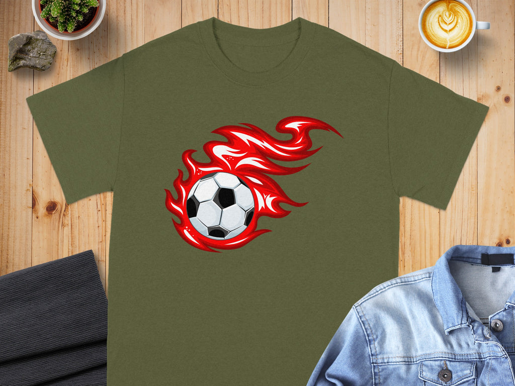 Green t-shirt with black and white soccer ball surrounded by red flames graphic.