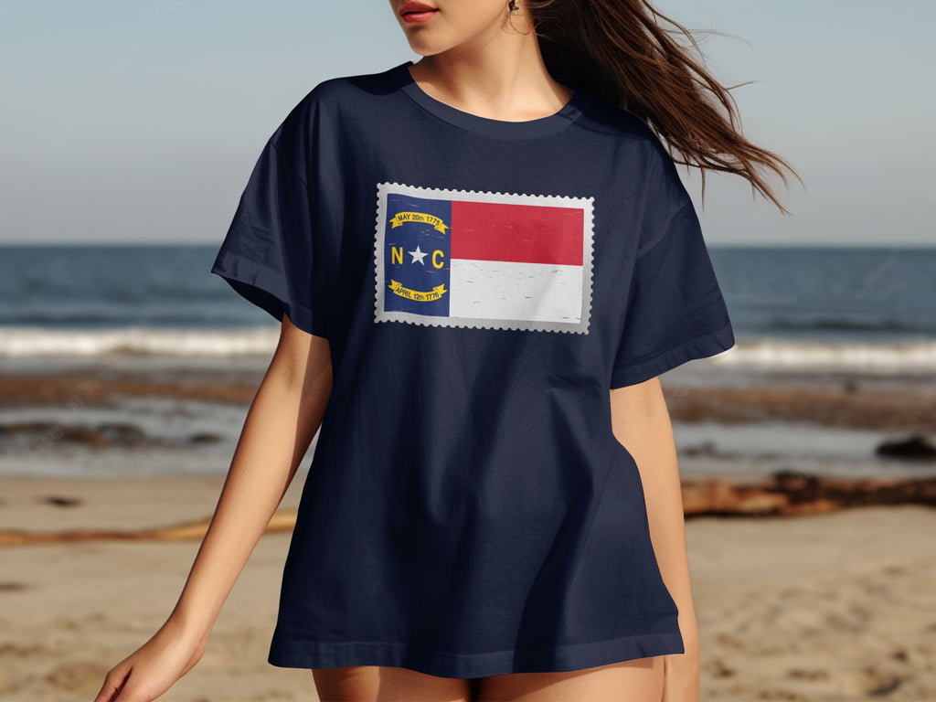 Navy t-shirt with North Carolina flag design in a stamp shape.