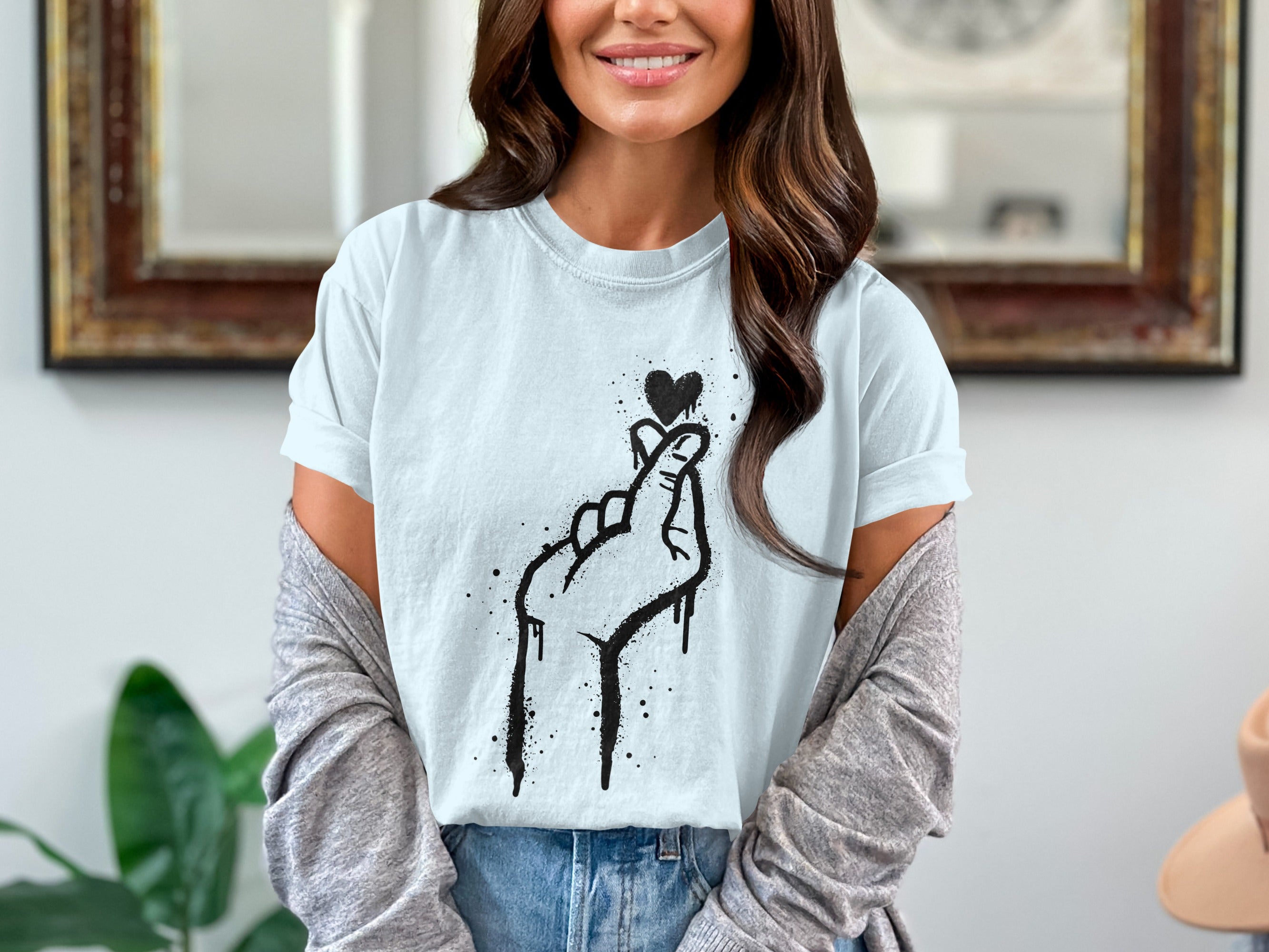 Light blue t-shirt with a black hand gesture heart graphic and dripping paint effect.