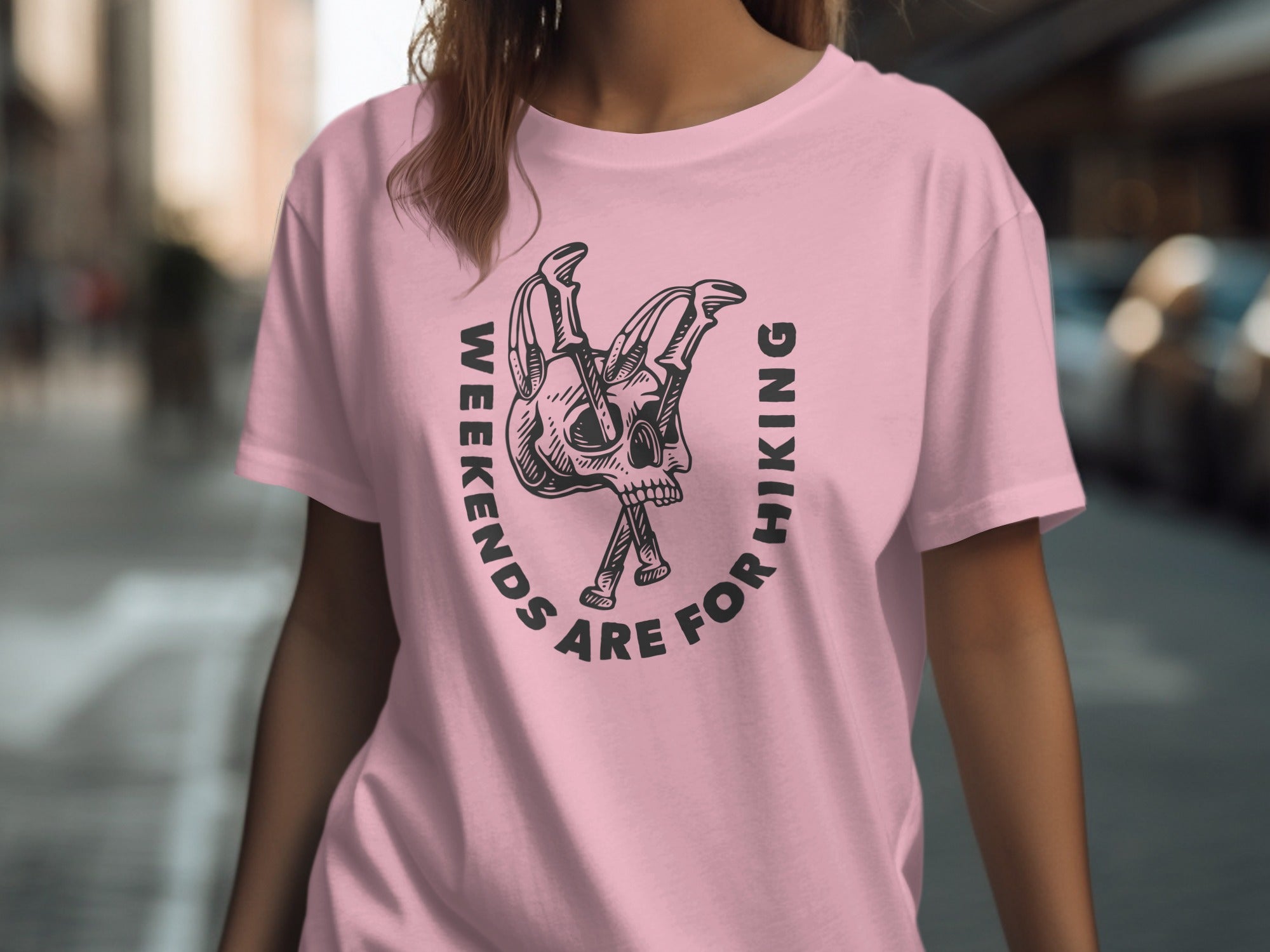 Pink t-shirt with black graphic of a skull and crossed hiking poles with text.
