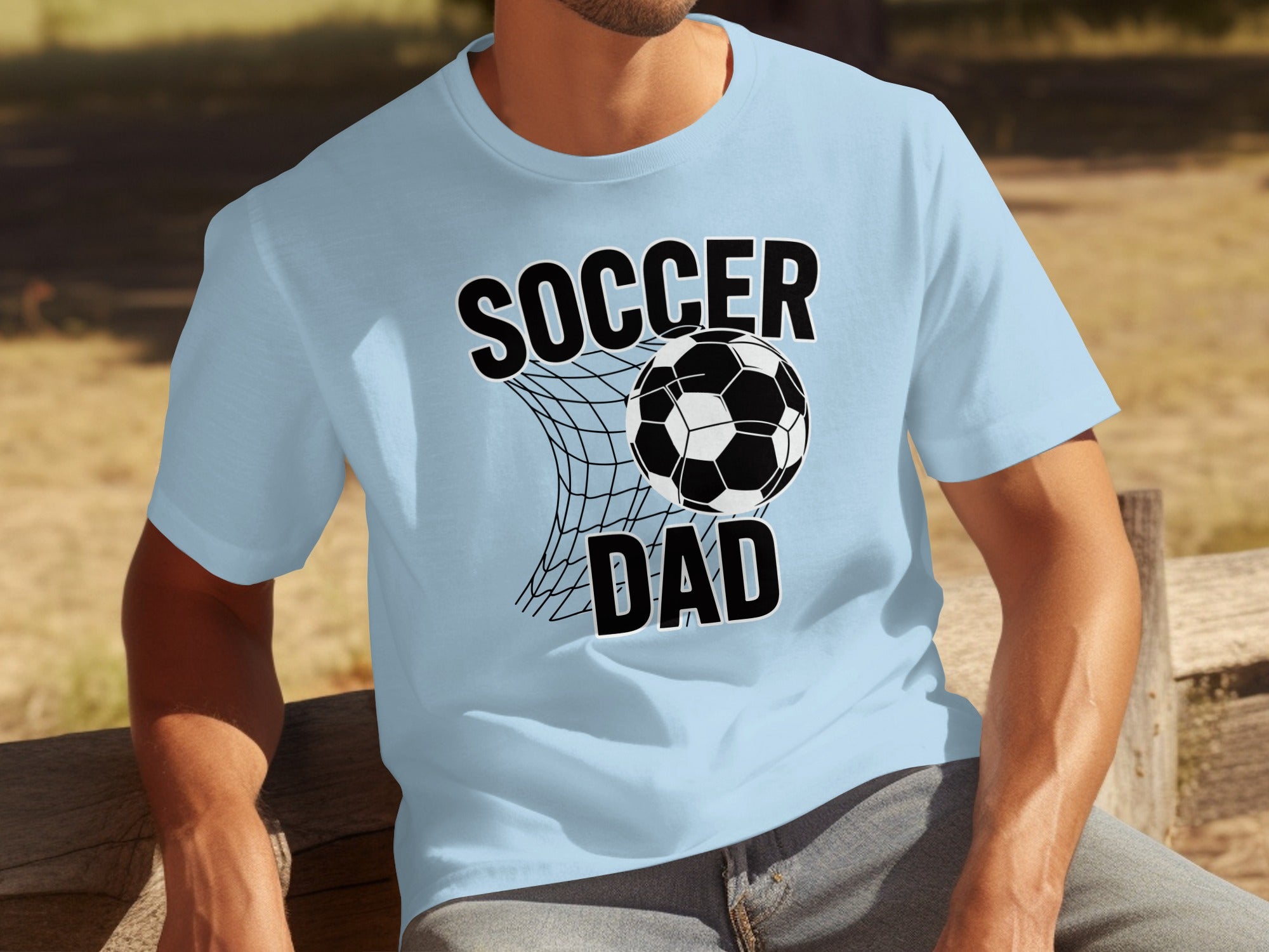 Light blue t-shirt with "SOCCER DAD" and a soccer ball in a net graphic.