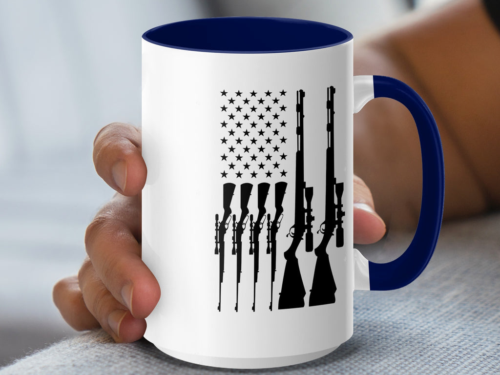 White mug with blue interior and handle, featuring rifles and stars forming an American flag.
