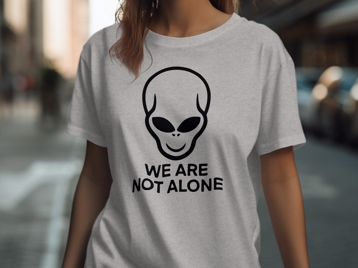 Grey t-shirt with black alien graphic and text "WE ARE NOT ALONE".