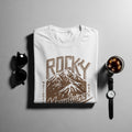 White t-shirt with "Rocky Mountains National Park" text and mountain graphic.