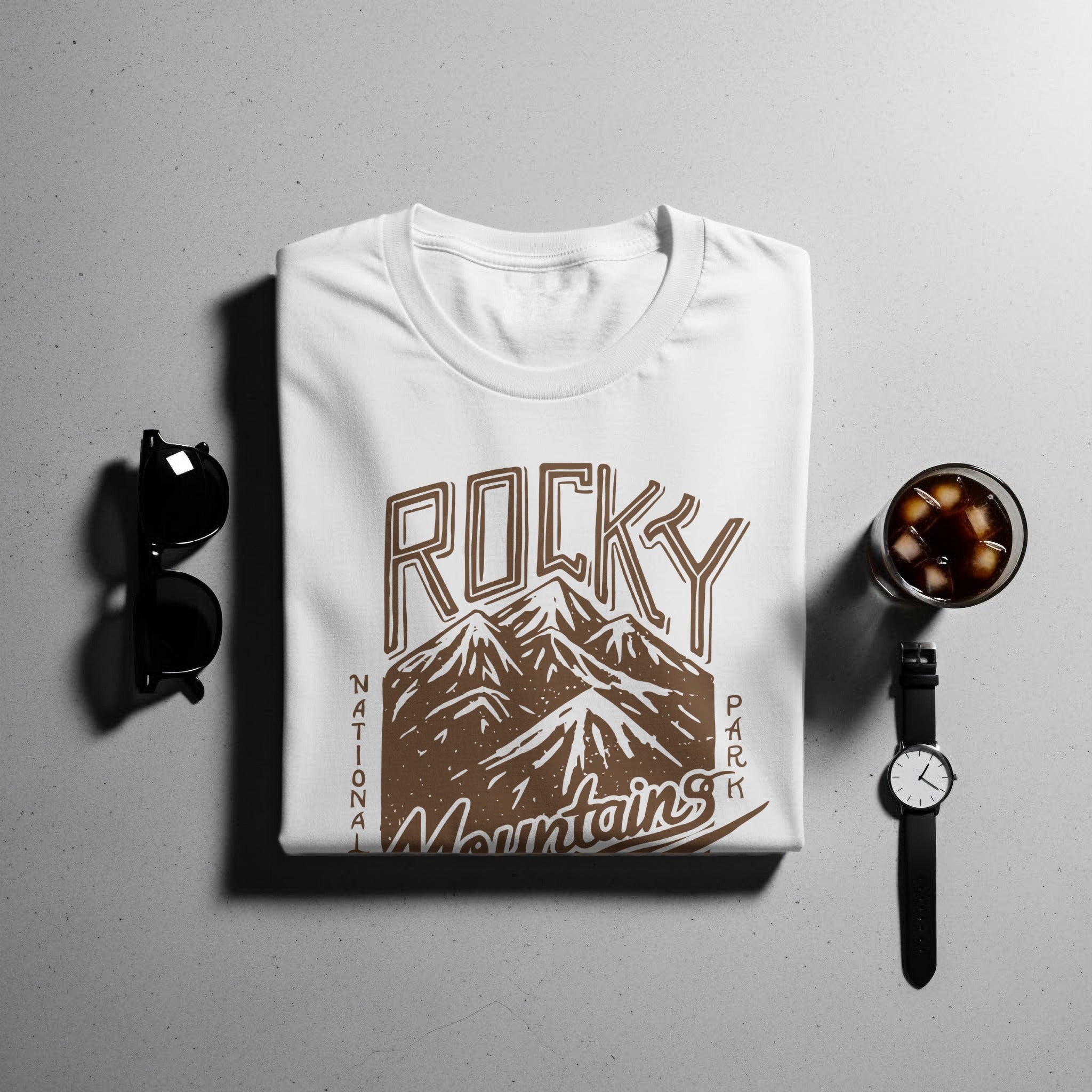 White t-shirt with "Rocky Mountains National Park" text and mountain graphic.