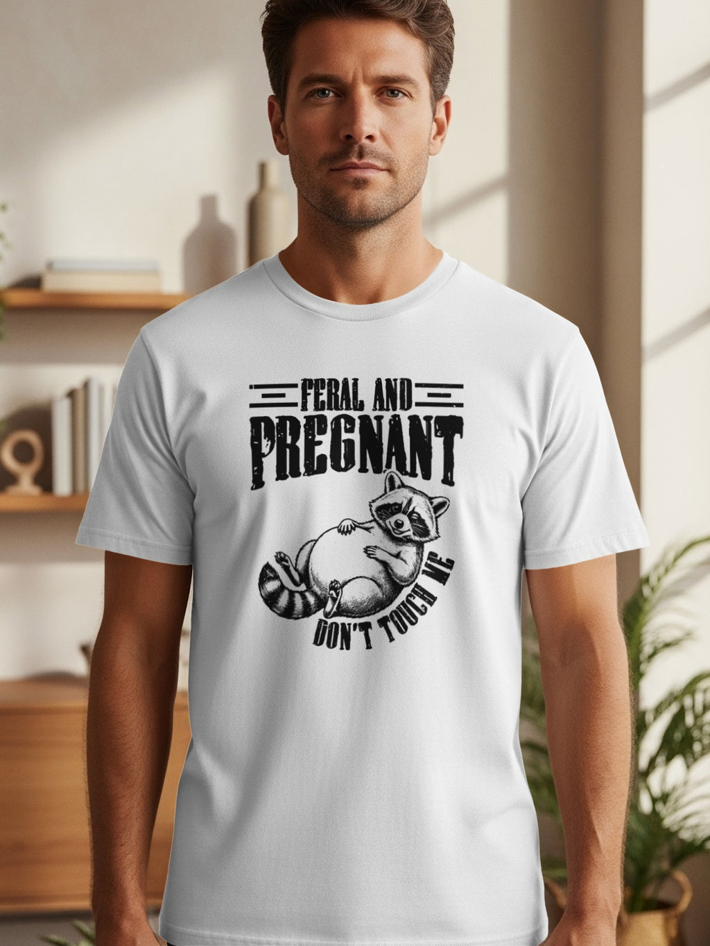 White t-shirt with black graphic reading "Feral and Pregnant" and a raccoon saying "Don't Touch Me".