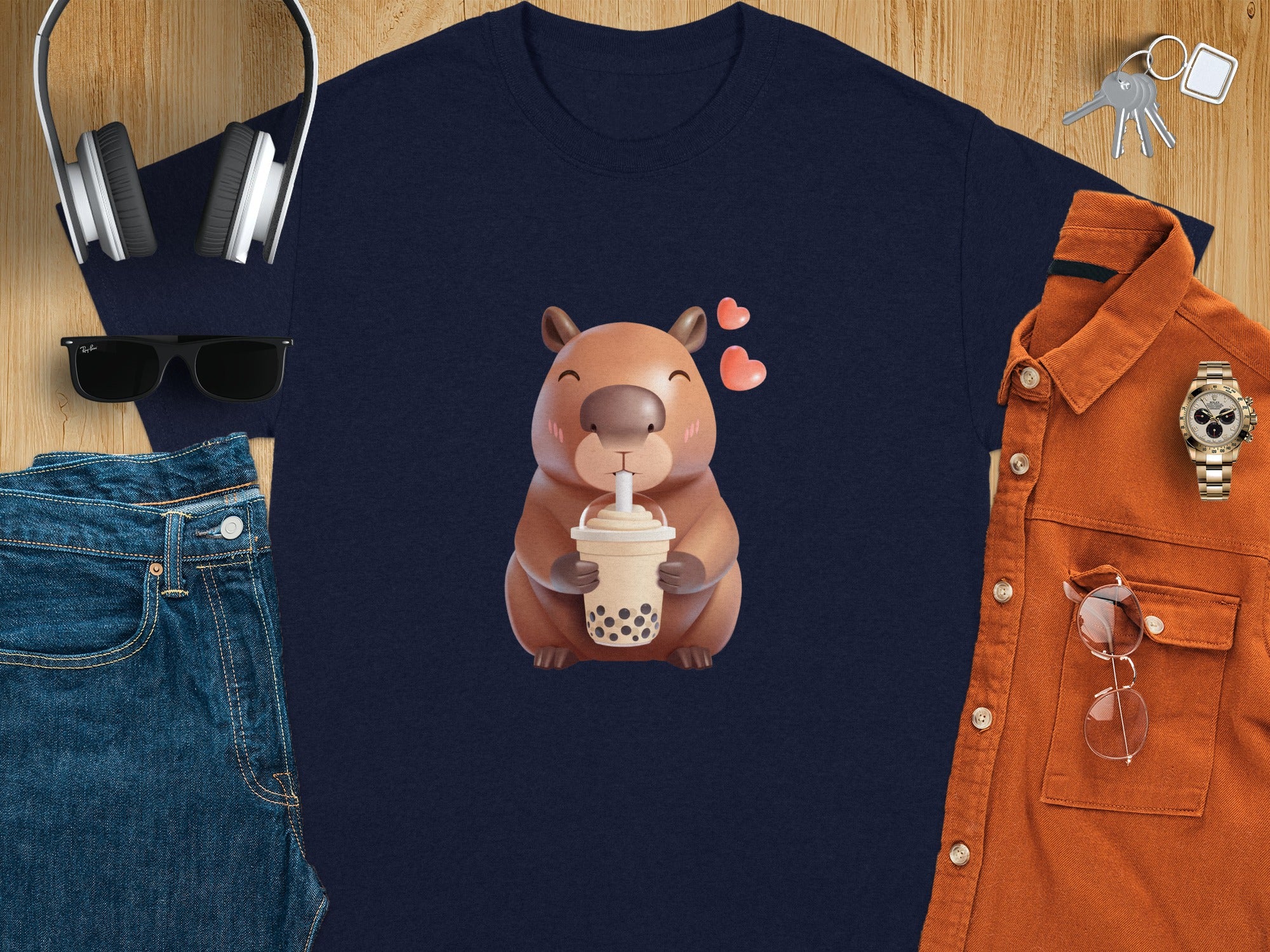 Navy t-shirt with a cartoon capybara holding a boba tea, surrounded by accessories.