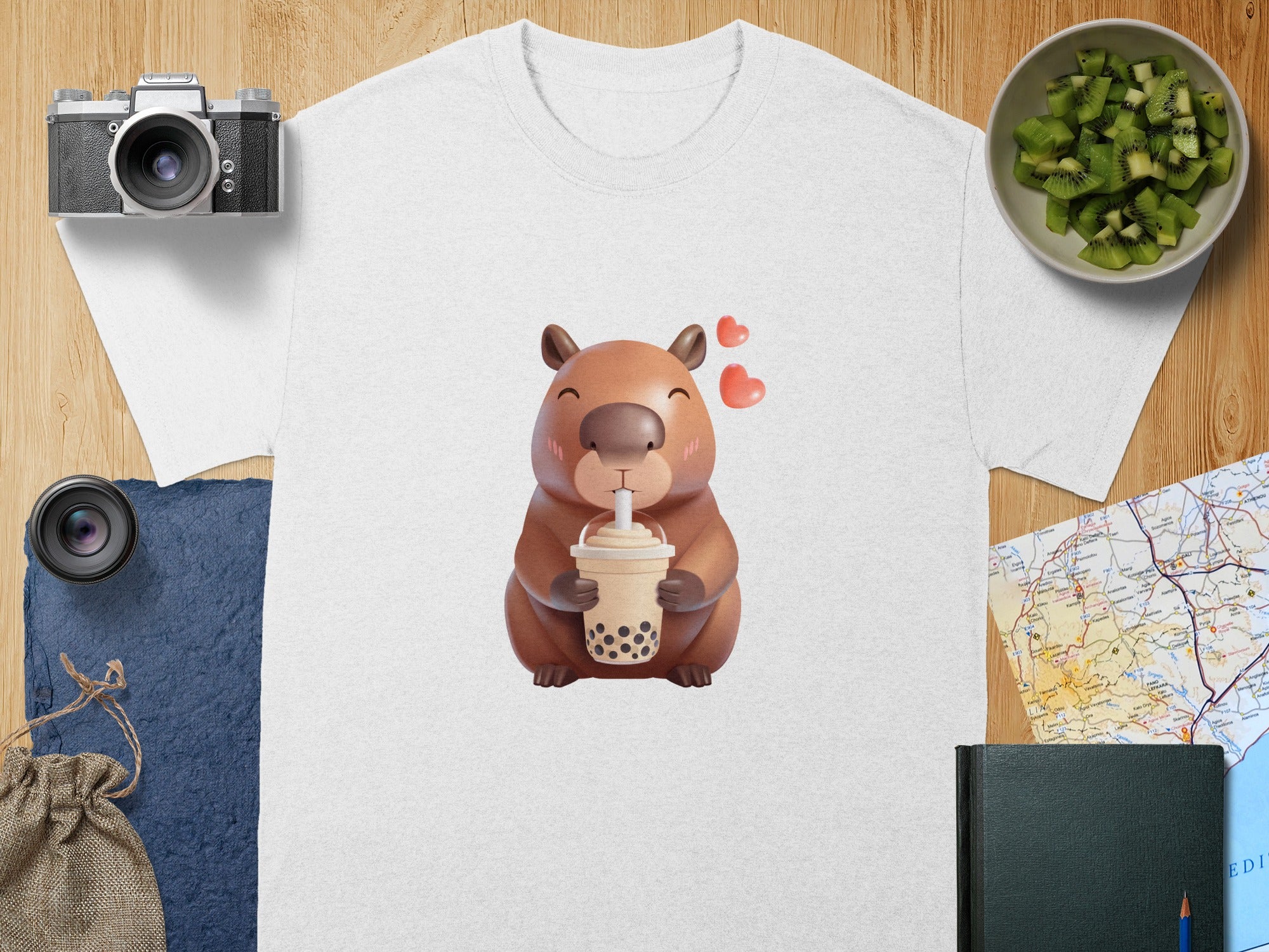 White t-shirt with cartoon capybara drinking bubble tea and two pink hearts.