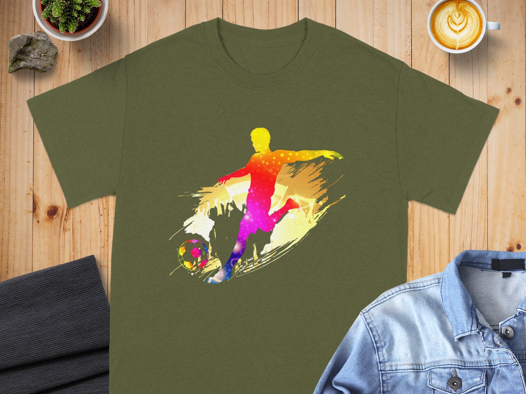 Green t-shirt with a colorful silhouette of a soccer player kicking a ball.