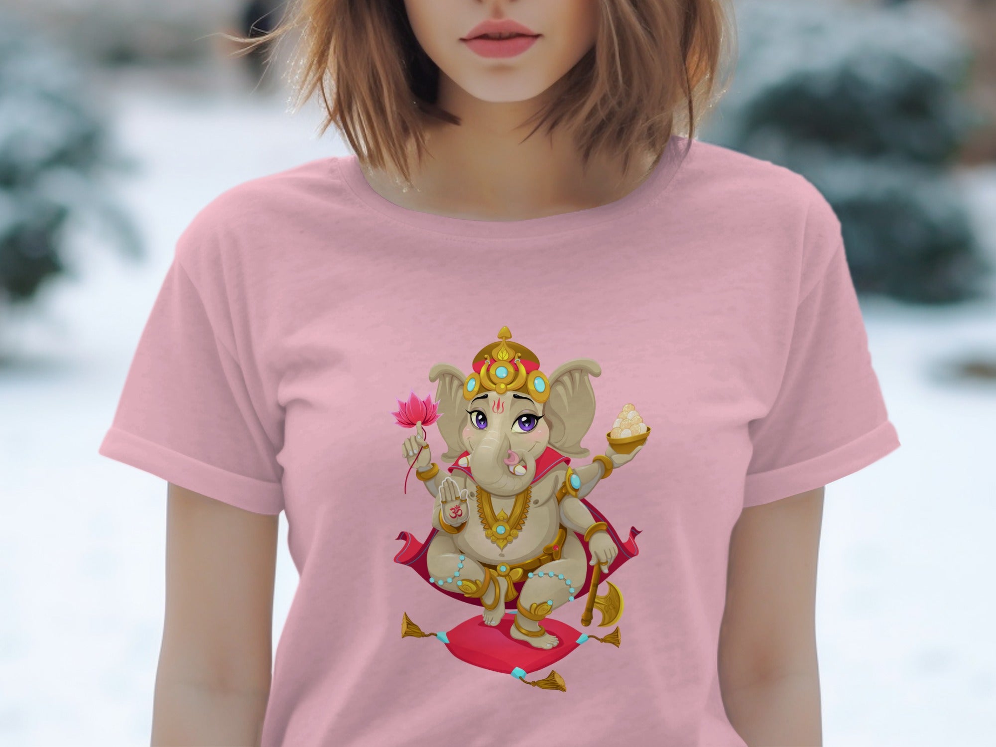 Pink t-shirt with cartoon Ganesha holding a lotus and sweet treats.
