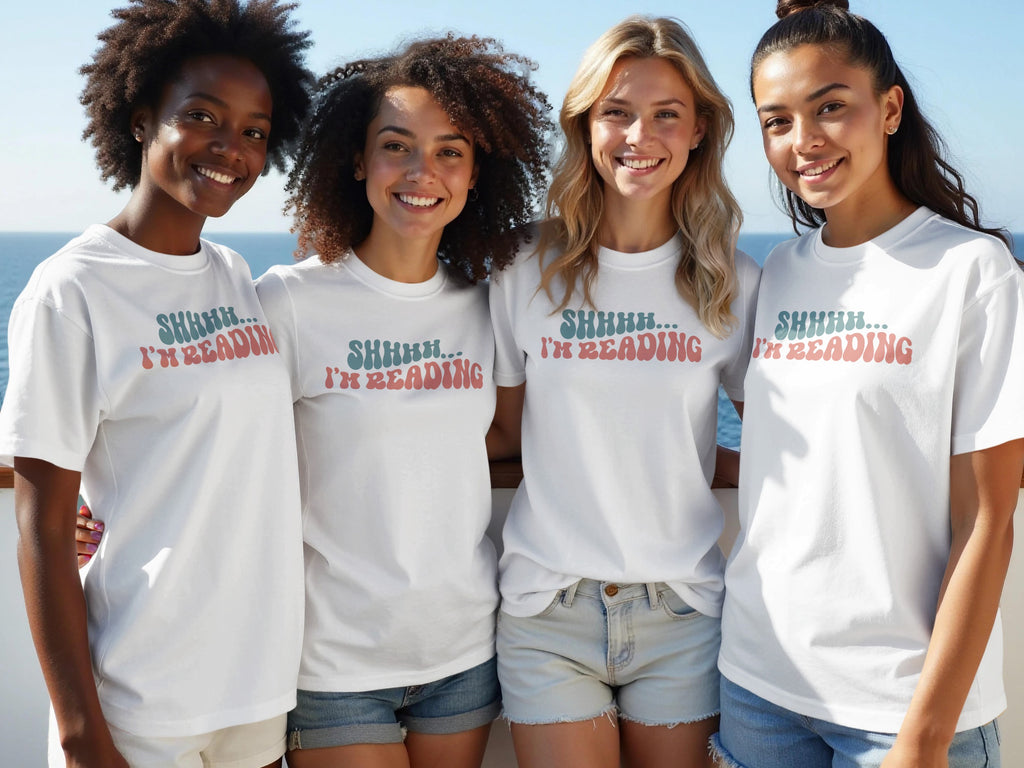 Four women wear white t-shirts with "SHHHH... I'M READING" text.