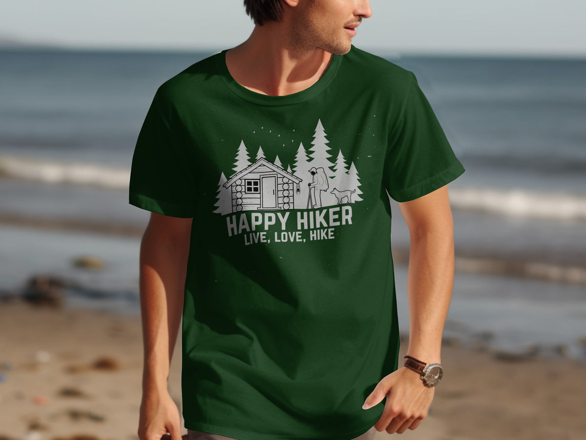 Green t-shirt with a graphic of a cabin, trees, hiker, and dog. Text reads "HAPPY HIKER LIVE, LOVE, HIKE".