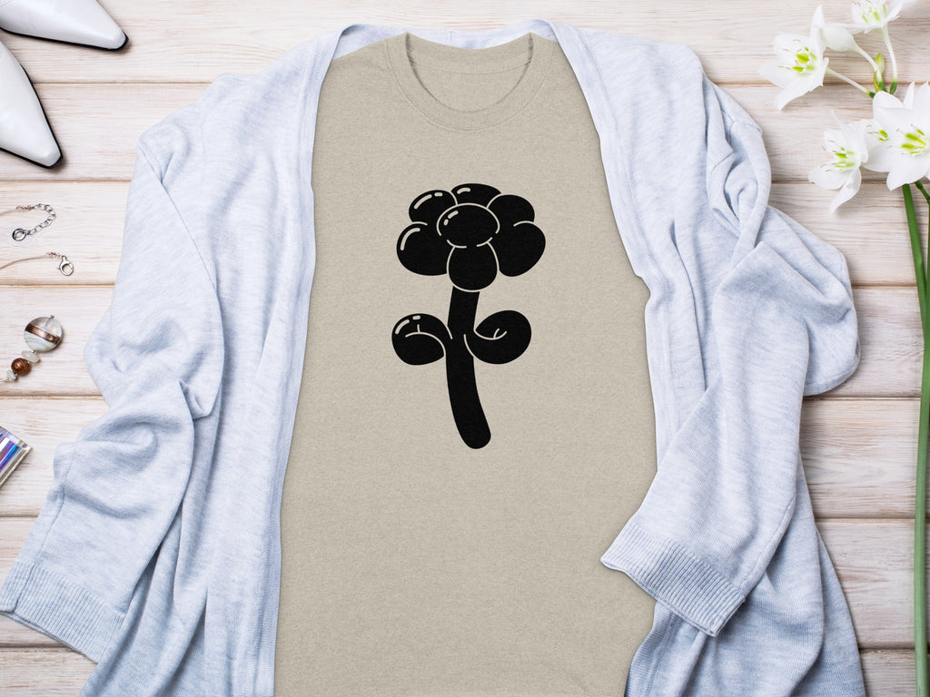 Tan t-shirt with a black balloon flower graphic, styled with a light blue cardigan.